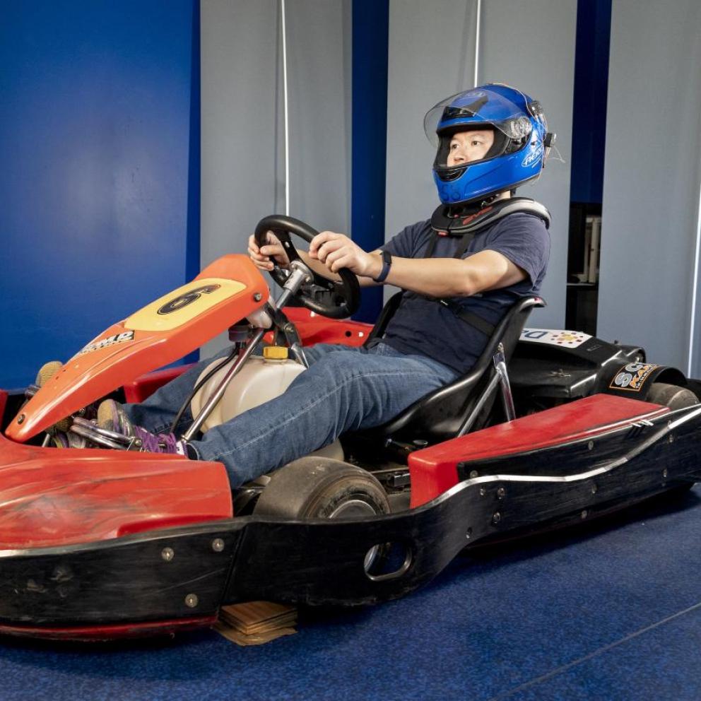Personne sur un kart portant un casque équipé de capteurs et des protections