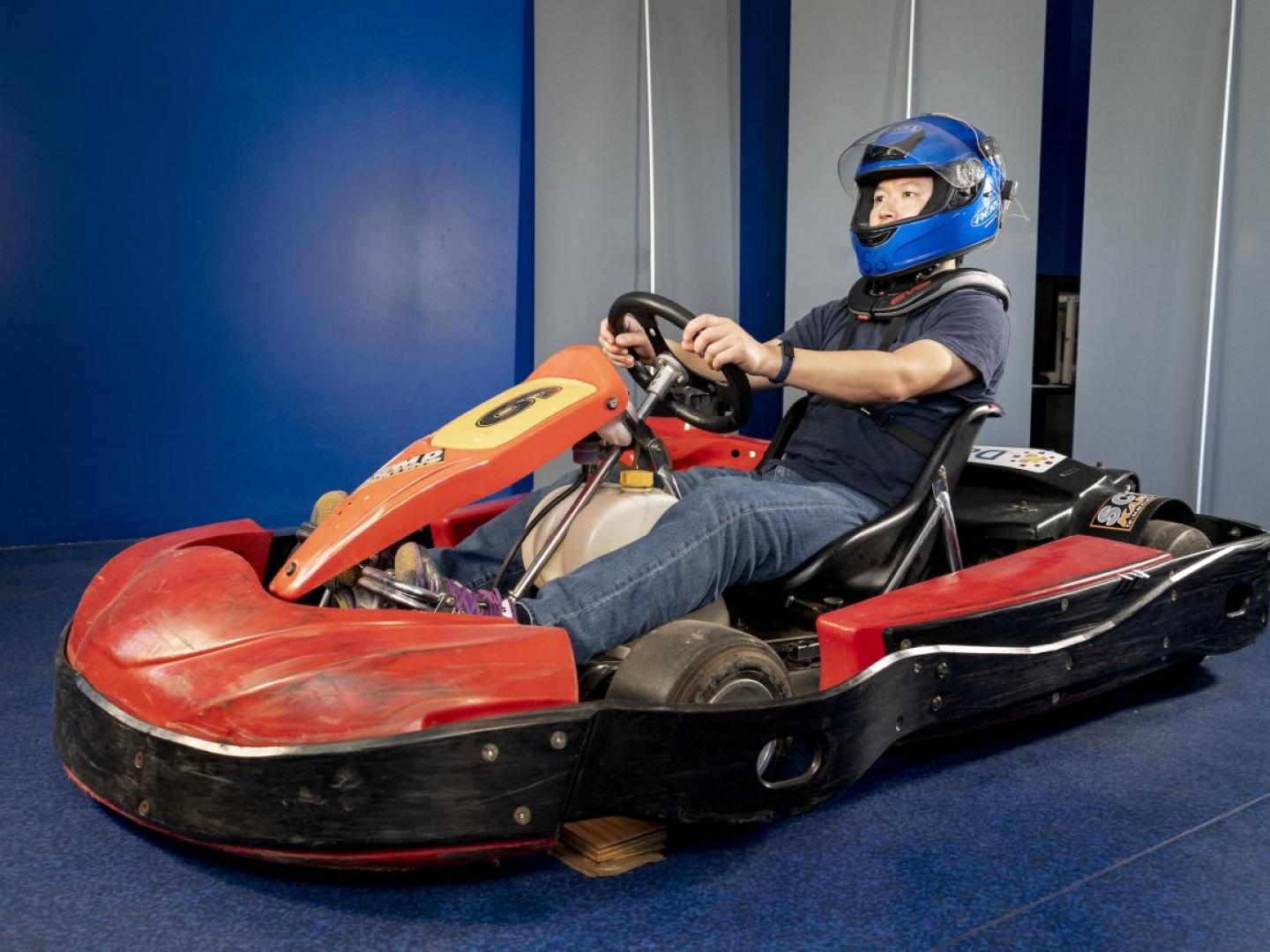 Personne sur un kart portant un casque équipé de capteurs et des protections